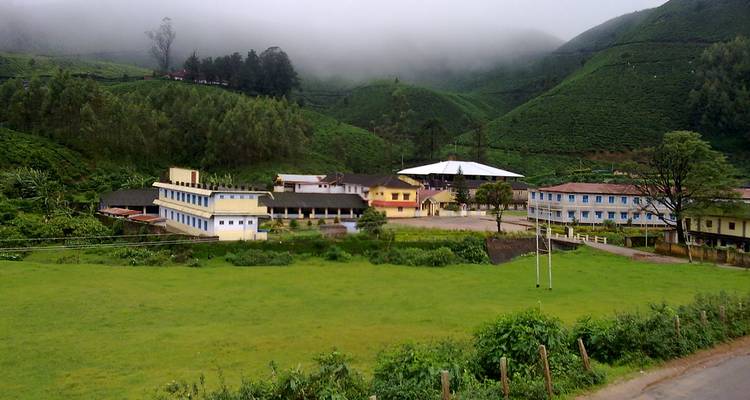Buildings in a misty lush green valley.