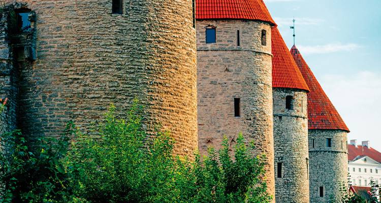 Nahaufnahme von steinernen mittelalterlichen Türmen unter blauem Himmel.