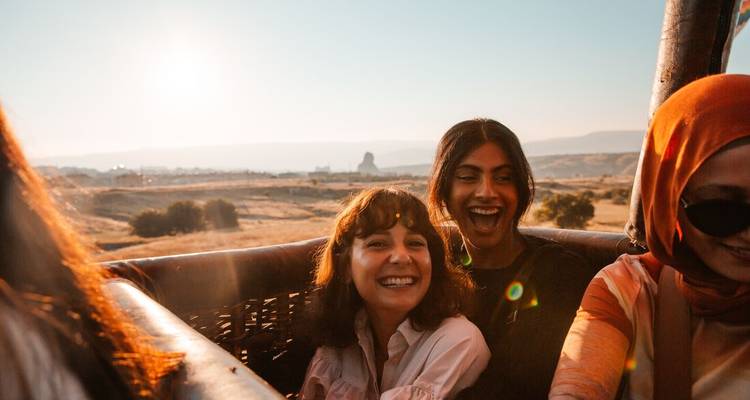 People smiling in a hot air balloon.