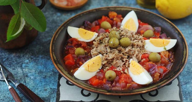 Tunisian dish with eggs, tuna, and olives served in a bowl.