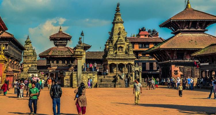 Place Durbar de Patan avec temples et gens qui marchent.