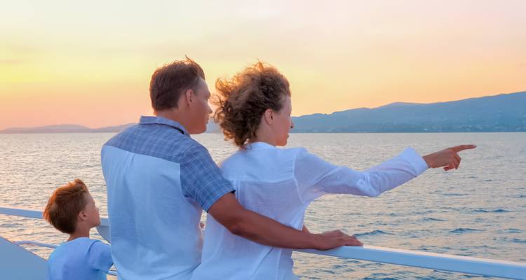 Famille profitant d'une vue sur le coucher de soleil depuis le pont d'un bateau.