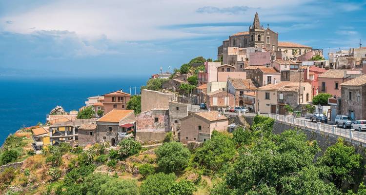 Hillside village overlooking the sea with rustic buildings.