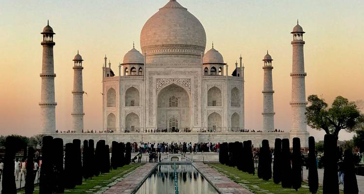 The Taj Mahal with a crowd of people, captured at sunset.