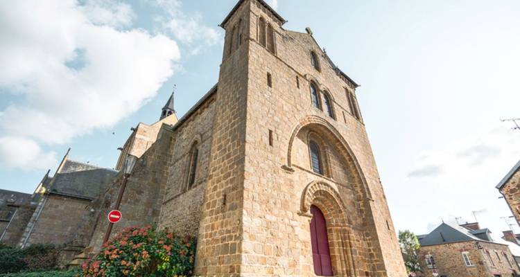 Old stone church with a red door under the blue sky.