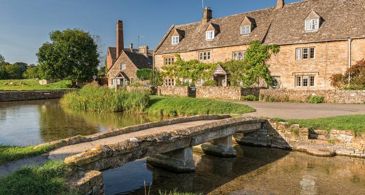 Picturesque village with stone cottages and a small bridge over a river.