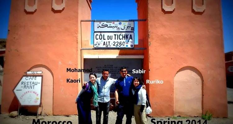 Groupe de personnes debout devant un panneau avec des noms superposés.