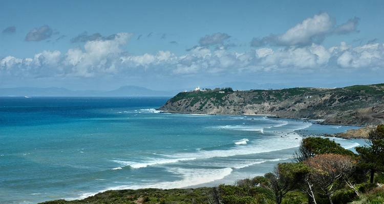 Un paysage côtier avec des vagues qui se brisent contre des falaises escarpées.