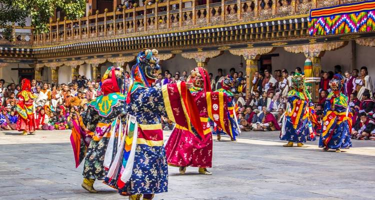 Danse traditionnelle avec des interprètes en costumes colorés dans une cour.
