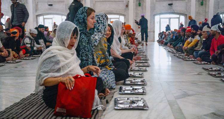 Group sitting in a temple setting preparing for a meal.