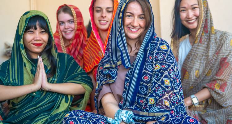 Group of people dressed in colorful attire smiling at the camera.