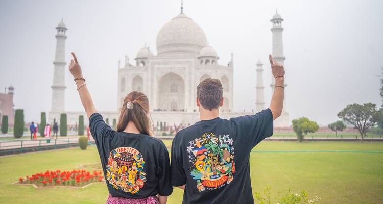 Tourists posing with the Taj Mahal in the background.