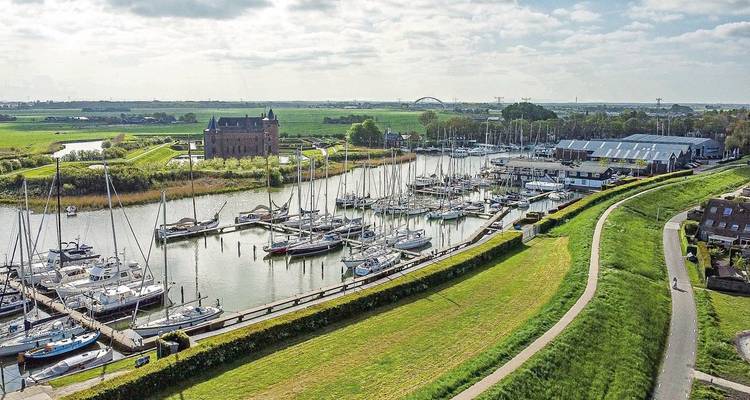 Marina with sailboats and a historical building in the background.