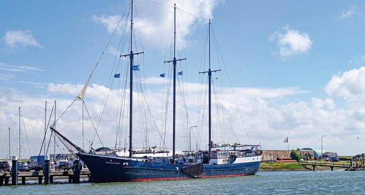 Un grand voilier amarré avec un ciel dégagé au-dessus.