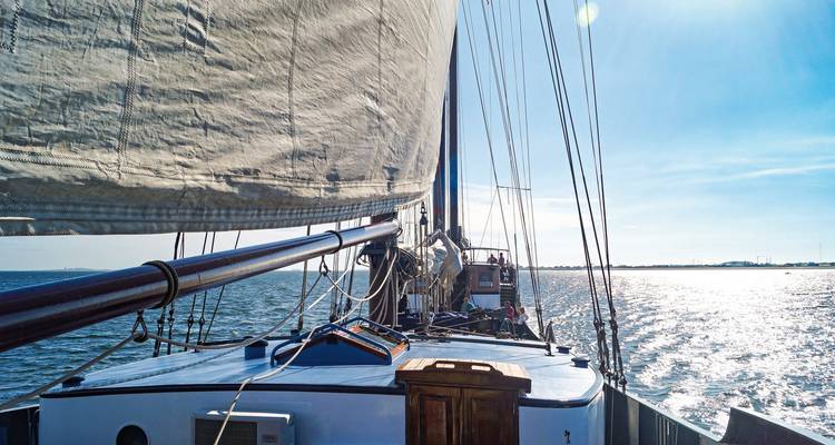 Une vue depuis un yacht naviguant avec sa voile déployée.