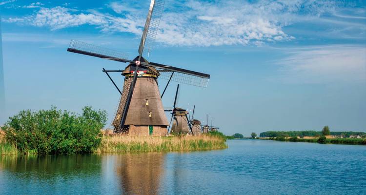 Série de moulins à vent traditionnels le long d'un canal.
