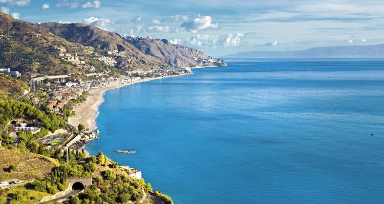 Aerial view of a coastal area with clear blue waters.