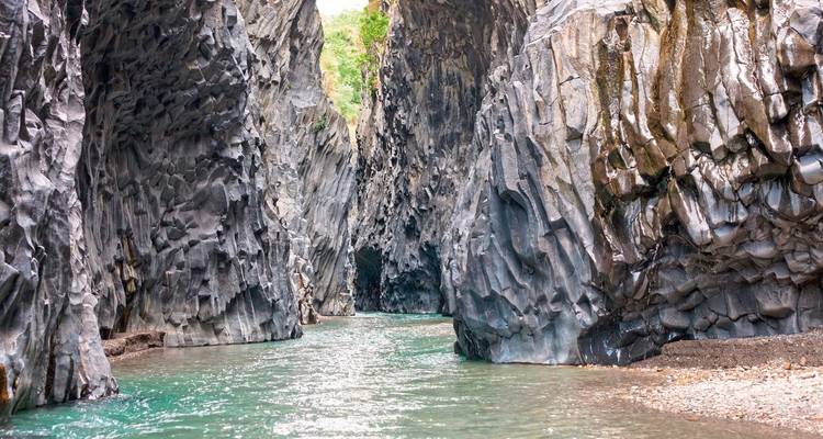 Rocky gorge with a clear, flowing river in the midst.