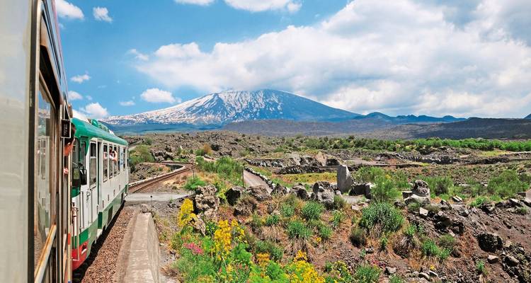 Vintage train traveling near a scenic mountain.