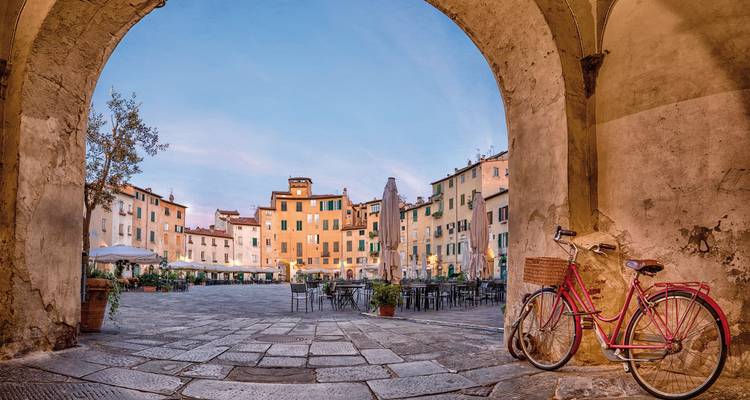 Charming Italian piazza seen through an arch with a vintage bike.