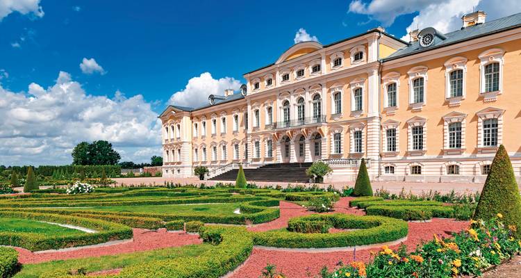 Baroque palace with manicured gardens in front.