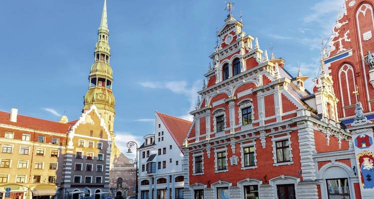 Colorful historic buildings with a tall tower in a city square.