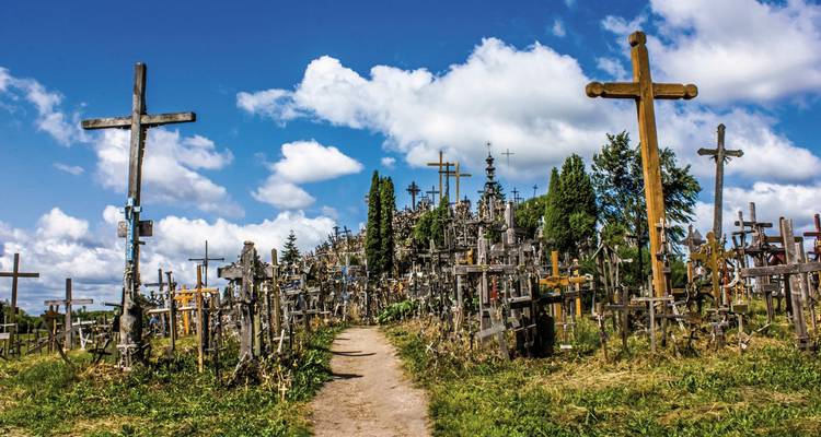 Hill covered with numerous crosses under a blue sky.