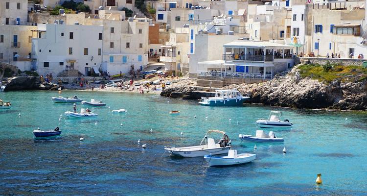 Une ville côtière avec des bâtiments blancs et des bateaux dans l'eau bleue.