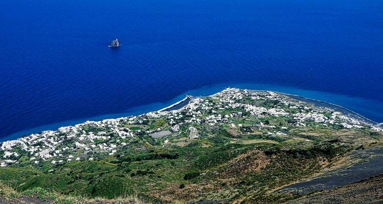 Hoog luchtfoto van het witgekalkte stadje op eiland Stromboli tegen de uitgestrekte open zee