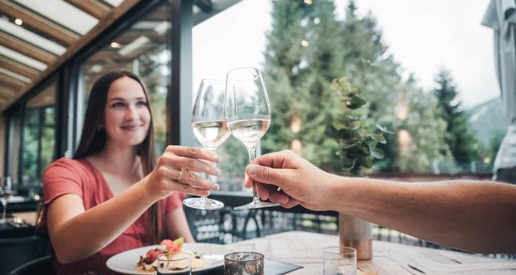 Indoor dining scene with a woman raising a glass.
