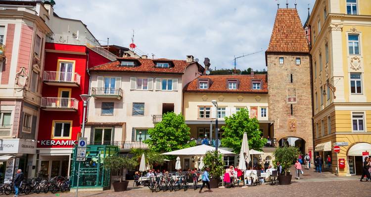 Town square with colorful buildings and people walking.