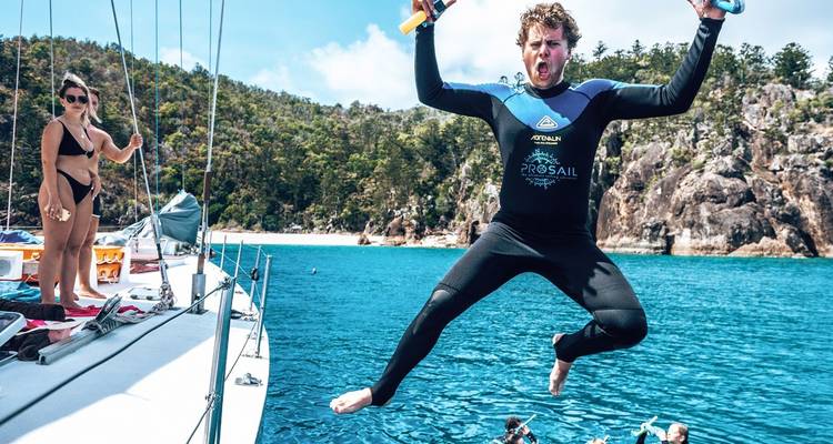 Man jumping off a sailboat into the sea.