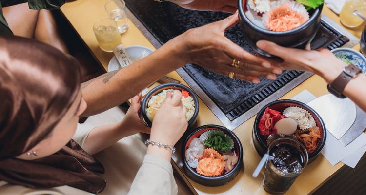 People enjoying traditional Japanese meals at a table.
