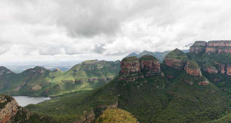 Een adembenemend uitzicht op ruige bergen onder een bewolkte hemel.