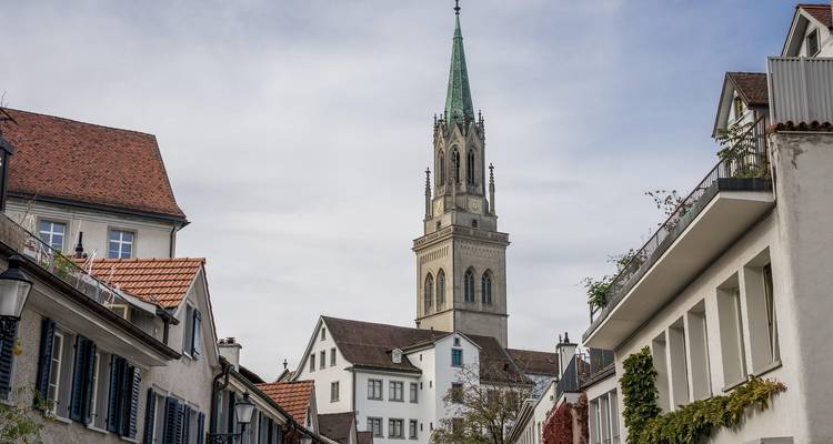 Street view with historic church tower and residential buildings.