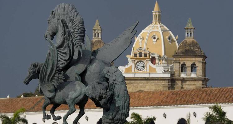 Une statue de cheval avec un bâtiment à dôme en arrière-plan.