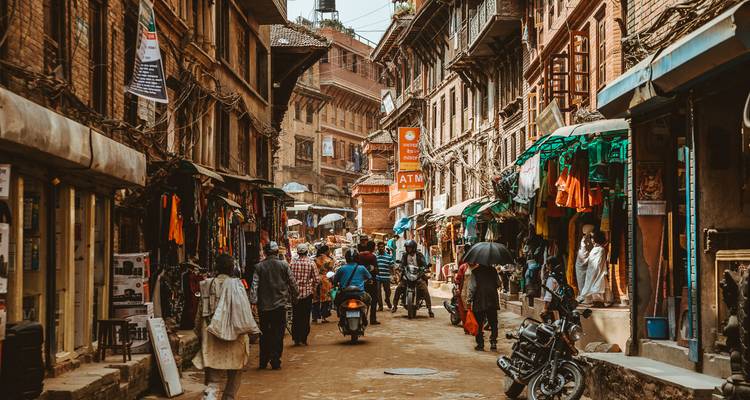 Drukke straatscène met mensen en winkels in een oude stad.