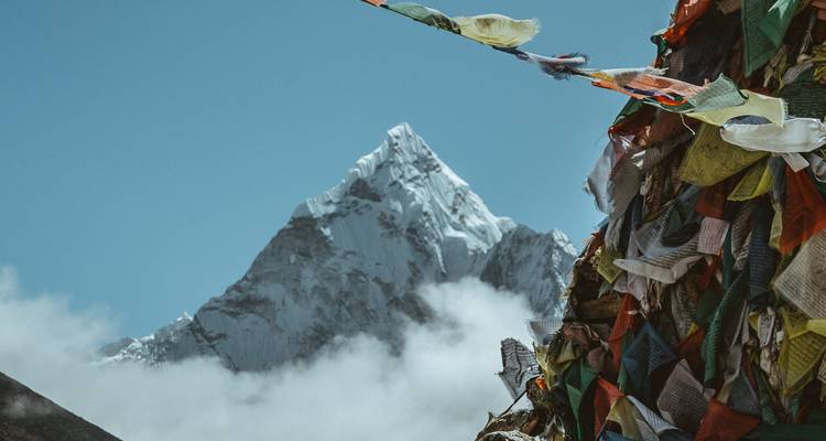 Berglandschap met gebedsvlaggen en een bergtop.