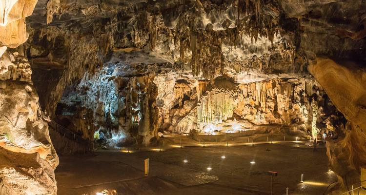 Intérieur de grotte éclairé avec stalactites.