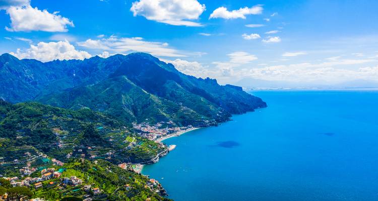 Weitläufiger Blick auf die Küstenlinie mit Bergen, die im Hintergrund aufragen.