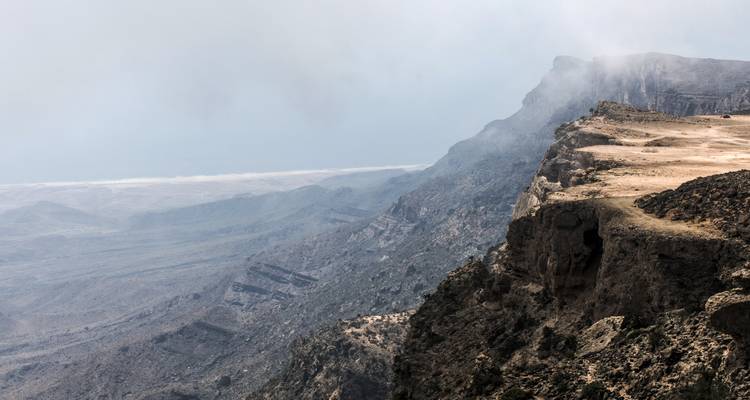A dramatic mountain range with mist creating a mysterious atmosphere.