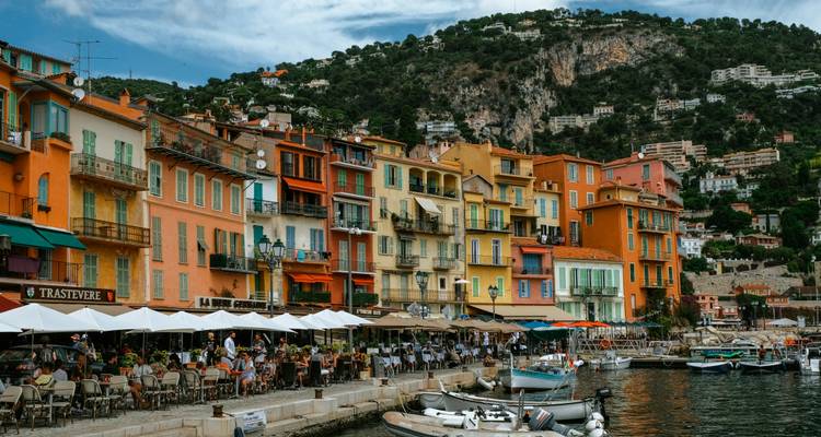 Bâtiments colorés le long d'une marina avec des bateaux amarrés.