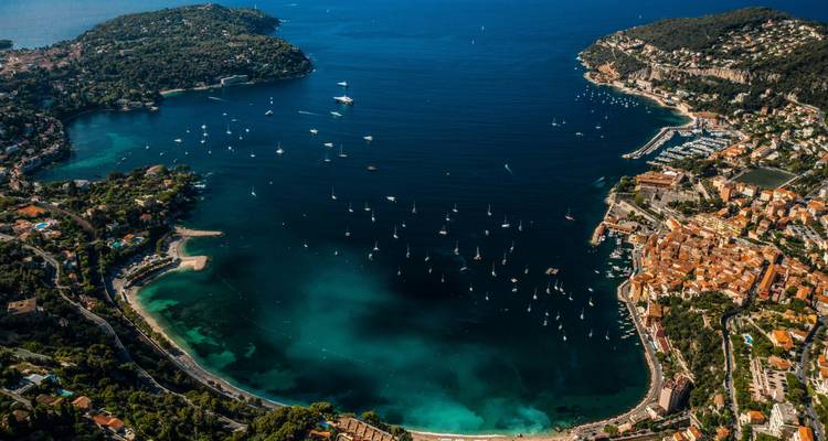 Vue aérienne d'une baie magnifique avec des eaux cristallines et des bateaux.