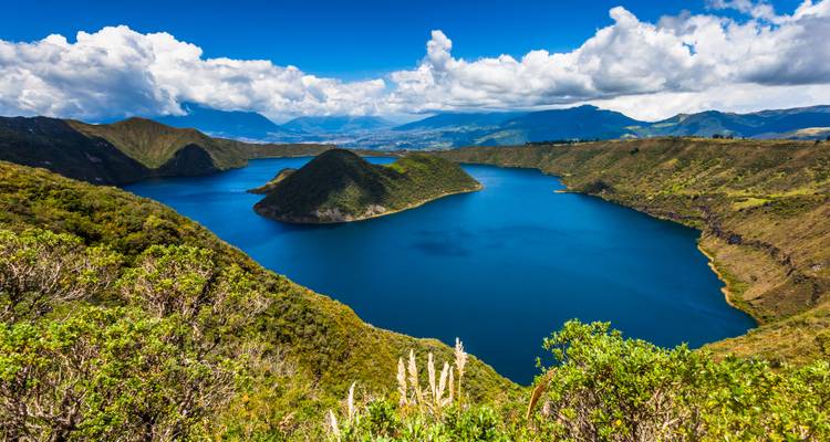 Une vue panoramique d'un lac de cratère entouré de collines verdoyantes.