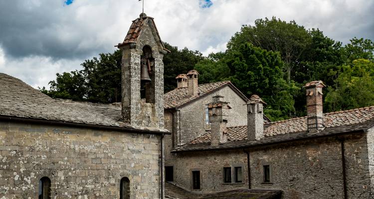 Stone building with bell towers against a cloudy sky.