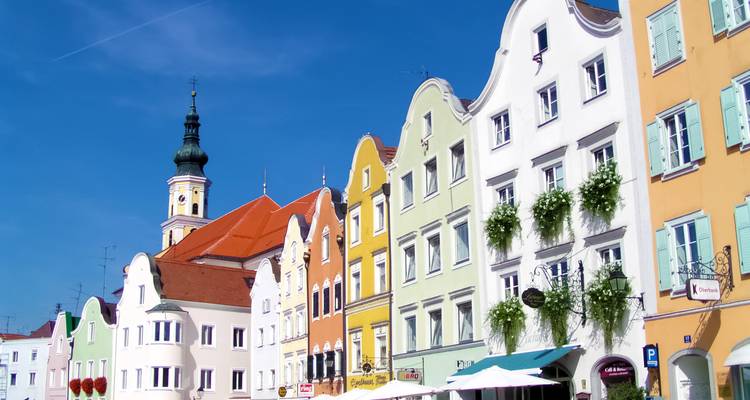 Bunte Gebäude mit einem Kirchturm an einem hellen Tag in einer europäischen Stadt.