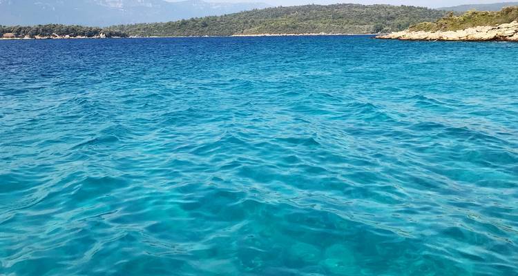 Blauwe oceaan met verre bergen zichtbaar.