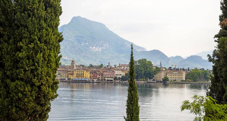 View of a lake with a town and mountains in the background.