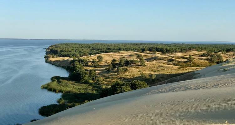 Küstenlandschaft mit Sanddünen und einem Gewässer.
