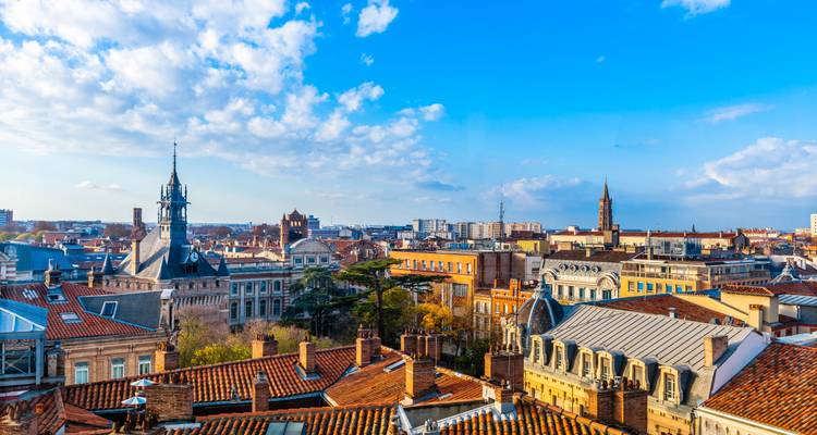 An aerial view of a city with historic rooftops and prominent spires.